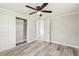 Neutral bedroom offers a ceiling fan, spacious closet, and wood-look flooring for a modern touch at 10831 Manchester Rd, Port Richey, FL 34668