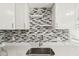 Close-up of sink area with mosaic backsplash and modern faucet at 10831 Manchester Rd, Port Richey, FL 34668