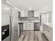 White kitchen with stainless steel appliances and a decorative mosaic backsplash at 10831 Manchester Rd, Port Richey, FL 34668