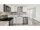 Bright kitchen featuring white cabinets, stainless steel appliances, and mosaic backsplash at 10831 Manchester Rd, Port Richey, FL 34668