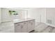 Bright kitchen with a gray and white island, and light gray wood-look flooring at 10831 Manchester Rd, Port Richey, FL 34668