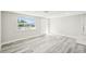 Bright living room area with gray wood flooring, and new windows at 10831 Manchester Rd, Port Richey, FL 34668