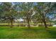 Spacious backyard with mature trees lining the waterfront, offering privacy and serenity at 10921 Cory Lake Dr, Tampa, FL 33647