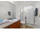 Bright bathroom featuring granite counters, a glass shower door, and tiled flooring at 10921 Cory Lake Dr, Tampa, FL 33647