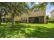 Exterior view of home with a well-maintained lawn and screened patio area at 10921 Cory Lake Dr, Tampa, FL 33647
