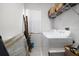 Utility room featuring a white washer and dryer, shelving, and natural light from a window at 10921 Cory Lake Dr, Tampa, FL 33647
