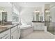 Bathroom featuring dual vanities, tub and glass-door shower at 11311 Striped Bass Ct, New Port Richey, FL 34654