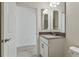 Bathroom vanity with a gray countertop and chrome faucet fixture, with a view to the toilet and shower at 11311 Striped Bass Ct, New Port Richey, FL 34654