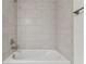 Bright bathroom with a tiled tub and shower combo featuring brushed chrome fixtures at 11311 Striped Bass Ct, New Port Richey, FL 34654