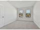 Inviting bedroom featuring neutral carpet, two windows, and white walls providing serene space at 11311 Striped Bass Ct, New Port Richey, FL 34654