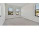 Bright, carpeted bedroom with three windows providing natural light and views of the neighborhood at 11311 Striped Bass Ct, New Port Richey, FL 34654