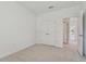 Neutral carpeted bedroom with closet, bright white walls and open doorway to another room at 11311 Striped Bass Ct, New Port Richey, FL 34654