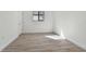 Well-lit bedroom showcasing sleek, wood-look floors, a double door, and a bright, minimalist aesthetic at 11311 Striped Bass Ct, New Port Richey, FL 34654