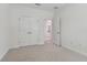 Neutral carpeted bedroom with closet, bright white walls and open doorway to another room at 11311 Striped Bass Ct, New Port Richey, FL 34654