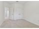 Neutral carpeted bedroom with closet, bright white walls and open doorway to another room at 11311 Striped Bass Ct, New Port Richey, FL 34654
