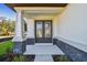 Stylish double front doors with glass panels and stone facade, showcasing a grand entrance at 11311 Striped Bass Ct, New Port Richey, FL 34654