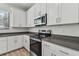 Close up of a stainless steel oven and microwave with white cabinets and grey countertop at 11311 Striped Bass Ct, New Port Richey, FL 34654
