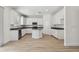 Well-lit kitchen with an island, stainless appliances, light wood floors, and all-white color scheme at 11311 Striped Bass Ct, New Port Richey, FL 34654