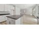 Open-concept kitchen island with dark countertop and a view of the spacious living area at 11311 Striped Bass Ct, New Port Richey, FL 34654