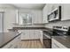 Bright kitchen with stainless steel appliances, grey countertop, and white cabinetry at 11311 Striped Bass Ct, New Port Richey, FL 34654