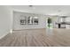 Spacious living room with wood floors, recessed lighting, and sliding glass doors to the outdoor space and kitchen at 11311 Striped Bass Ct, New Port Richey, FL 34654