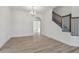 Open concept living room featuring wood flooring, a modern chandelier, and a staircase with decorative metal spindles at 11311 Striped Bass Ct, New Port Richey, FL 34654