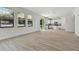 Bright open-concept living room with wood floors, recessed lighting, and view of the kitchen with white cabinets at 11311 Striped Bass Ct, New Port Richey, FL 34654