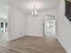 Open concept living room with wood flooring, modern chandelier, and arched doorway leading to another room at 11311 Striped Bass Ct, New Port Richey, FL 34654
