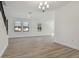 Open living room with wood-look floors, lots of natural light, and view of the staircase with decorative metal spindles at 11311 Striped Bass Ct, New Port Richey, FL 34654