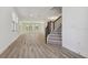 Open-concept living room with hardwood floors, abundant natural light, and stairs at 11311 Striped Bass Ct, New Port Richey, FL 34654