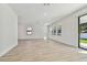 Bright and airy living room featuring wood floors, recessed lighting, and a sliding glass door to the outdoor space at 11311 Striped Bass Ct, New Port Richey, FL 34654
