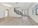Bright and airy living room with wood floors, modern chandelier, and staircase with decorative metal spindles at 11311 Striped Bass Ct, New Port Richey, FL 34654