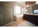 A primary bathroom featuring a glass enclosed shower, a garden tub, and a double vanity with dark cabinets at 12721 Avelar Creek Dr, Riverview, FL 33578