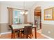 A dining room with wainscoting and a modern chandelier, adjacent to the kitchen at 12721 Avelar Creek Dr, Riverview, FL 33578