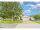 Charming single-story home with a two-car garage, manicured lawn, and tropical landscaping at 12721 Avelar Creek Dr, Riverview, FL 33578