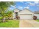 Charming single-story home with a two-car garage, manicured lawn, and tropical landscaping at 12721 Avelar Creek Dr, Riverview, FL 33578