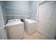 A well-lit laundry room with shelving, washer, and dryer at 12721 Avelar Creek Dr, Riverview, FL 33578