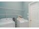 A well-lit laundry room with shelving, washer, and dryer at 12721 Avelar Creek Dr, Riverview, FL 33578
