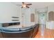Open-concept living room featuring wood floors and a ceiling fan, leading to a bright entryway at 12721 Avelar Creek Dr, Riverview, FL 33578
