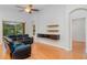 Bright living room featuring hardwood floors, a ceiling fan, and modern media center at 12721 Avelar Creek Dr, Riverview, FL 33578