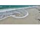 Close up of a sandy beach with foamy waves gently washing ashore at 1540 Gulf Blvd # 2107, Clearwater Beach, FL 33767