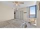 Serene bedroom features a comfy bed, ceiling fan, and a bright window offering scenic views, creating a peaceful retreat at 1540 Gulf Blvd # 2107, Clearwater Beach, FL 33767