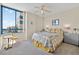 Cozy bedroom with a large window showcasing city views, complemented by a decorative chair and stylish furnishings at 1540 Gulf Blvd # 2107, Clearwater Beach, FL 33767