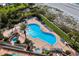 Aerial view of a Kidney-shaped pool with palm trees, lounge chairs, hot tubs, and grassy yard at 1540 Gulf Blvd # 2107, Clearwater Beach, FL 33767