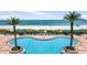 Sparkling swimming pool with a backdrop of the ocean and sandy beach at 1540 Gulf Blvd # 2107, Clearwater Beach, FL 33767