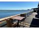 Outdoor seating area overlooking the bay with a table, two chairs, and a distant cityscape at 1540 Gulf Blvd # 2107, Clearwater Beach, FL 33767