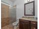 Bathroom with a tiled walk-in shower, granite countertop and wooden cabinets at 16304 Wild Mallard Dr, Odessa, FL 33556