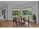 Dining room features floor-to-ceiling windows overlooking the backyard and a round table with seating for four at 16304 Wild Mallard Dr, Odessa, FL 33556