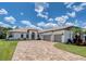 Beautiful single-story home with lush landscaping, a paver driveway, and a three-car garage at 16304 Wild Mallard Dr, Odessa, FL 33556