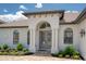 Close-up of a home's columned entry, featuring a decorative glass door and manicured landscaping at 16304 Wild Mallard Dr, Odessa, FL 33556